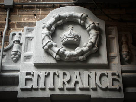 The lintel of the side door of the Magistracy is decorated by the royal family emblem