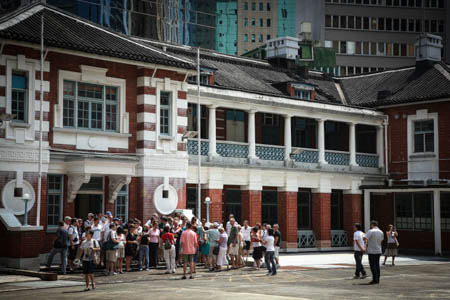 The facade of the Headquarters Block facing the Parade Ground is  built from red bricks and features verandas.