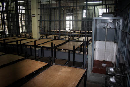 Each cage houses over a dozen double-layer bunk beds and a semi-open toilet