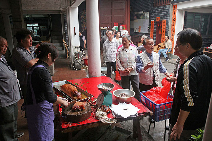 應鳳廖公家塾的族人在祠堂分豬肉，操刀者是一位女性