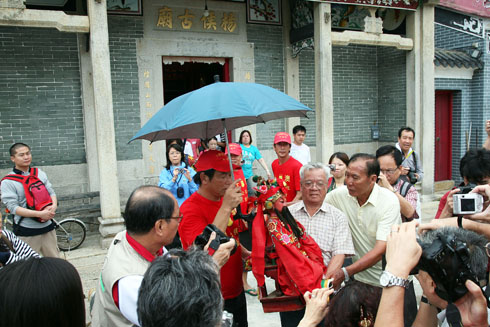 請神出廟時，成員為其打傘