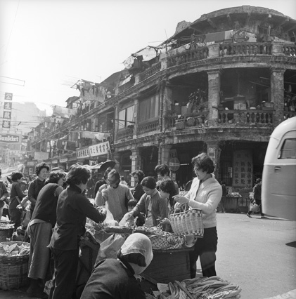 背景是街坊俗稱船屋的舊唐樓，今已拆建為玉器市場。炮仗街/甘肅街交畀，1968年。