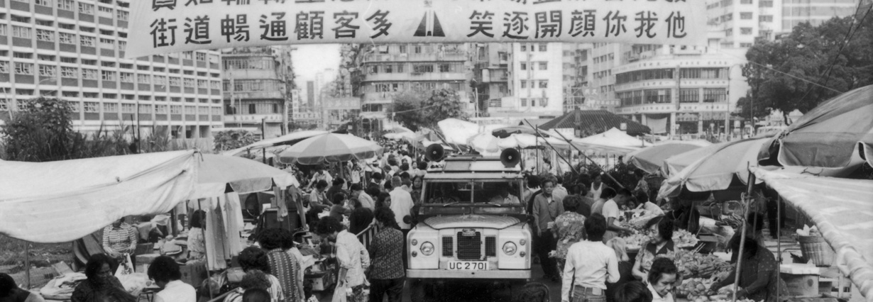 近榕樹頭的露天街市，左邊是賽馬會診所。上海街/街市街，1977年。