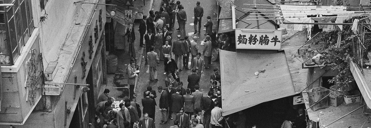 南京街左側爲人人茶樓，右側路旁熟食檔是楊財發牛什粉麵檔。廣東道/南京街交界，1974年。