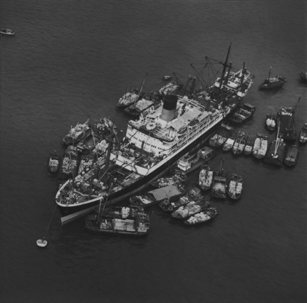 大貨船旁有小型貨艇及躉船。1968年。