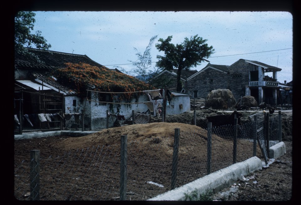 Facing the gate of the walled village is the three-roofed Village Council House.