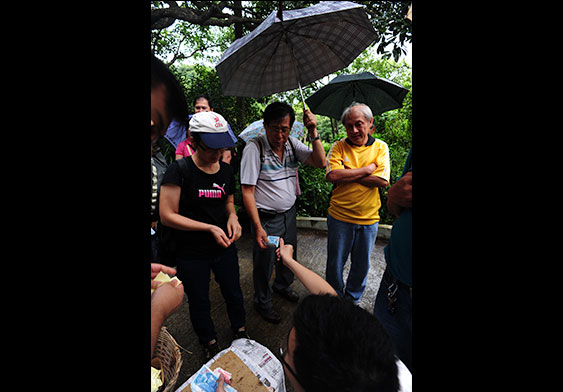 Distributing money before the grave of